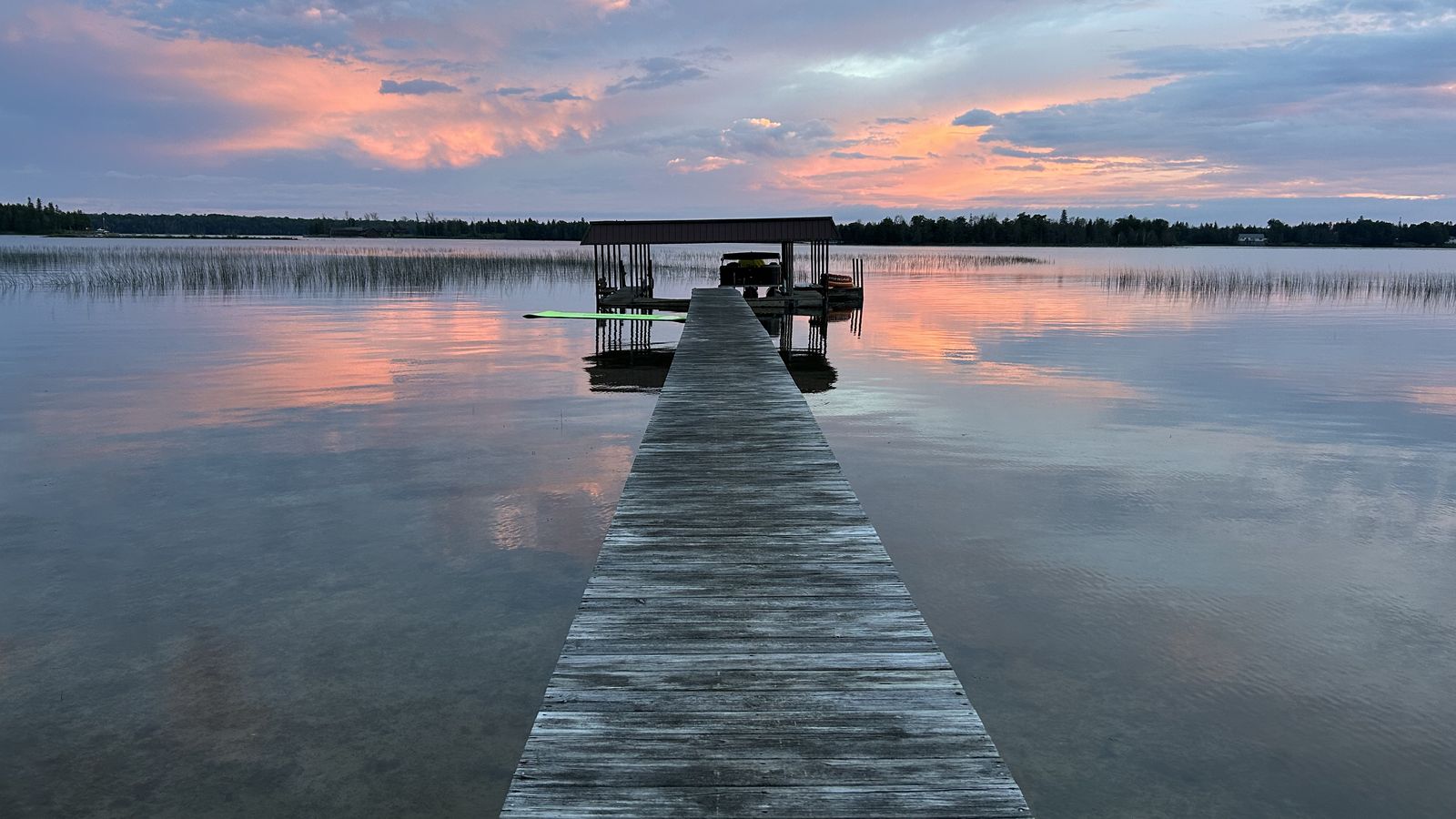 Dock and boathouse at sunset at Rob McKenney's place in Cedarville, Michigan